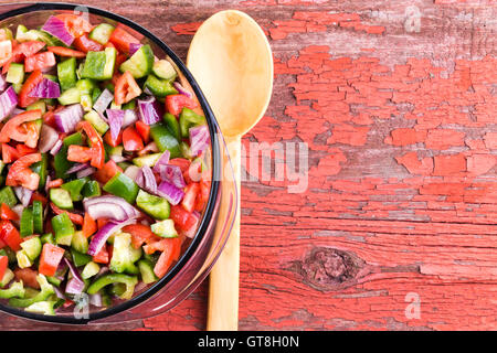 Schüssel mit gesunden traditionelle türkische Hirten Salat mit bunten feingeschnittene Sortiment an frischem Gemüse mit einem hölzernen servi Stockfoto