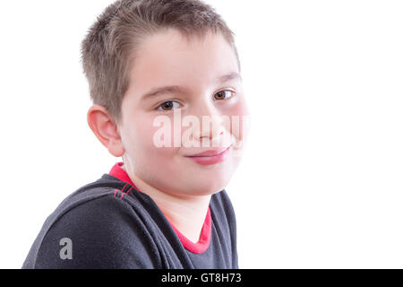 Kopf und Schultern Close Up Portrait Tween jungen schwarzen und roten T-Shirt und lächelnd über die Schulter in die Kamera im Stu Stockfoto