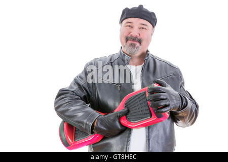 Inhalt gut aussehend Mann mittleren alten in Hut und Lederjacke steht mit einem roten und schwarzen Hoverboard in Händen mit Leder-Handschuh Stockfoto