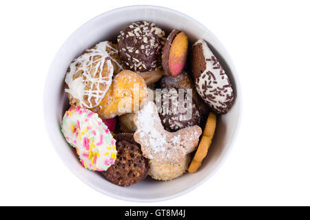 Leckere Auswahl an knackigen Cookies in einer weißen Schale oder Glas dekoriert mit Verglasung und Streusel in verschiedenen Formen, über Kopf vie Stockfoto