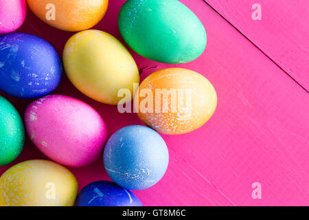 Cluster farbigen gefärbten natürlichen Hühner Eier zu Ostern in den Farben des Regenbogens auf eine exotische vivid Magenta Rosa aus Holz Hinterg Stockfoto