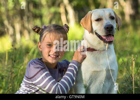 Glückliches kleines Mädchen mit ihrem Hund. Stockfoto