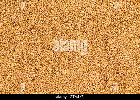 Hintergrundtextur von gerösteten goldenen Leinsamen oder Leinsamen mit gesunden Omega-3-Fettsäuren, Ballaststoffen, reich an Ölen und gebrauchte Stockfoto