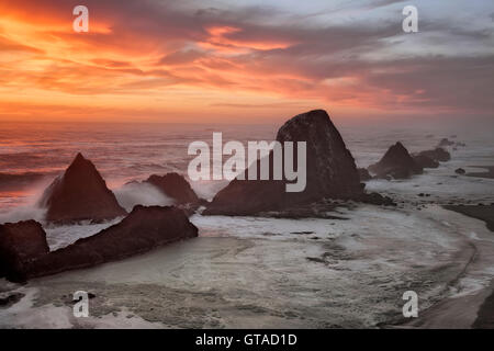 Wellen gegen die Felsnadeln, die Silhouette von dieser brillanten Sonnenuntergang im Oregons Seal Rock State Park. Stockfoto