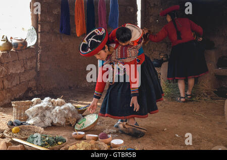 Einheimische Frau gekleidet in bunten Trachten, die Erläuterung der Fäden färben und Weben Stockfoto