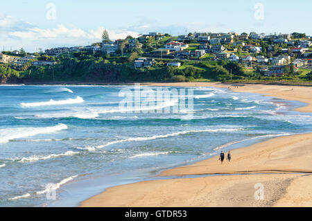 Zwei Personen gehen auf Bombo Beach, Sydney, New South Wales, NSW, Australien Stockfoto