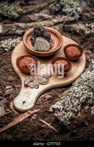 Dunkle Schokolade Praline mit Trüffeln auf Holzbrett Stockfoto