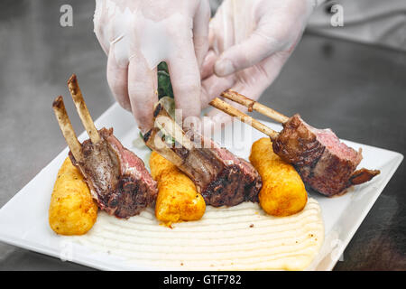 Lamm-Rippen auf weißen Teller serviert mit gestampften Kartoffeln gefüllte Kroketten Stockfoto