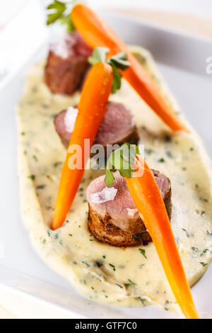 Gehobene Küche, Lende Schweinefleisch mit Karotten Stockfoto