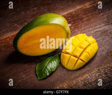 Mango-Frucht und Mango Würfel auf hölzernen Hintergrund Stockfoto