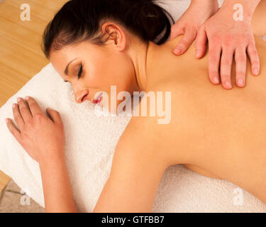 Schöne junge Frau mit einer erholsamen Massage im Wellness-Studio - Wellness Stockfoto