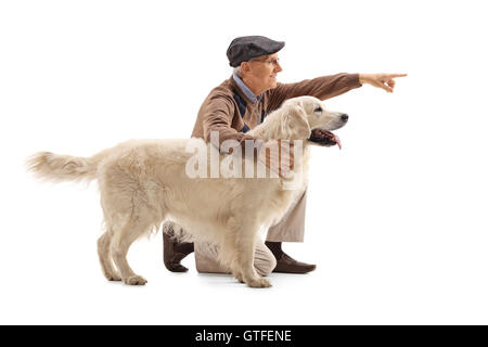 Älterer Mann zeigen etwas zu seinem Hund isoliert auf weißem Hintergrund Stockfoto