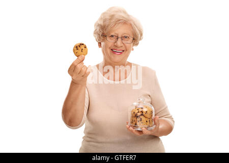 Glücklich Reife Frau hält ein Cookie und ein Glas voller Cookies isoliert auf weißem Hintergrund Stockfoto