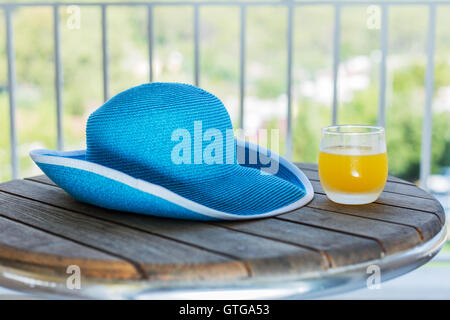 Glas orange Saft und Sonnenhut auf dem Holztisch. Stockfoto