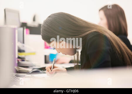 Geschäftsfrau schreiben am Schreibtisch im Büro konzentriert Stockfoto
