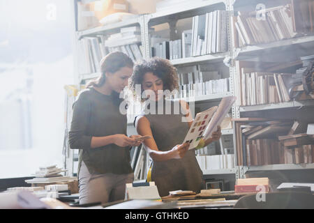Designerinnen diskutieren Papierkram im Büro Stockfoto