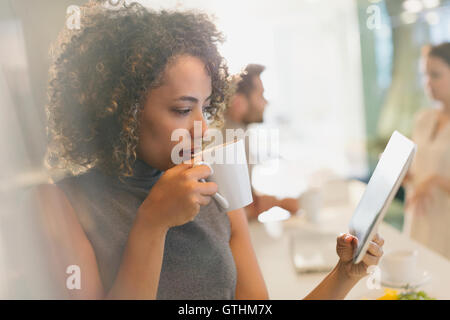 Geschäftsfrau, trinken Kaffee und mit digital-Tablette Stockfoto