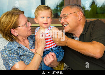 Familie Moment, Großeltern, die mit viel Spaß mit ihrem Enkelkind. Stockfoto