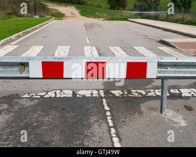 Rot-weiß gestreiften Ende das Straßenschild steht auf der anderen Straßenseite Stockfoto