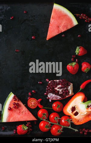 Auswahl an rote Früchte und Gemüse Wassermelone, Erdbeeren, Johannisbeeren, Paprika, Tomaten, Chilischoten, Granatapfel für ma Stockfoto