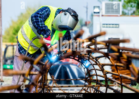 Schweißer-Arbeiter Schweißen Metall durch Elektrode mit hellen Lichtbogen und Funken bei der Herstellung von metallischen Geräten. selektive fo Stockfoto