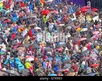 London, UK. 3. August 2012. Schirme nach oben in einer Menschenmenge beobachten die Leichtathletik im Sommer Olympischen Spiele in London 2012 Stockfoto