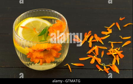 Ringelblume-Blume-Kräutertee mit Zitronenscheiben in einem Glas Stockfoto