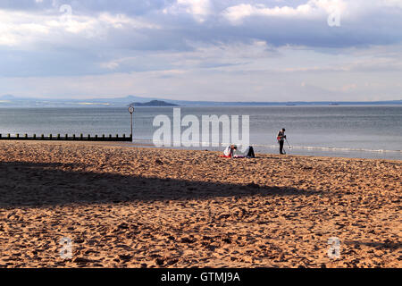 Menschen entspannen auf einem Strand, Portobello, Küstenvorort von Edinburgh, Scotland, UK Stockfoto