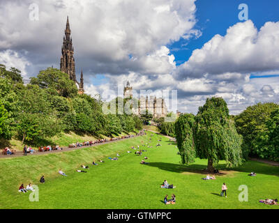 Menschen, die in den Princes Street Gardens, Edinburgh, an einem schönen Tag im Frühherbst mit Sonnenbaden mit Scott Monument und das Balmoral