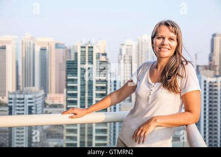 Gerne Frau mittleren Alters auf ihrem Balkon Stockfoto