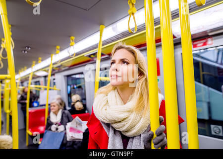 Schöne junge Frau im roten Mantel in u-Bahn Stockfoto