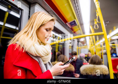 Schöne junge Frau mit Ihrem Smartphone in u-Bahn Stockfoto