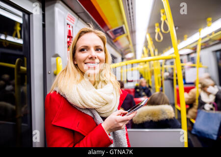 Schöne junge Frau mit Ihrem Smartphone in u-Bahn Stockfoto