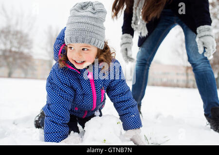 Mutter und Tochter im Winter Natur Schneemann bauen Stockfoto