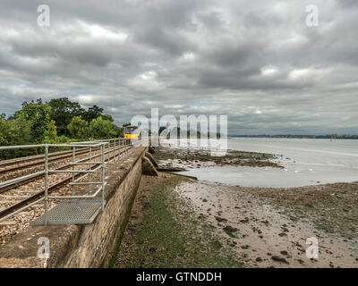 Landschaft abbildenden malerischen erstes Great Western Riviera Eisenbahnlinie entlang Fluß Exe an erstritt, mit Zug nähert. Stockfoto