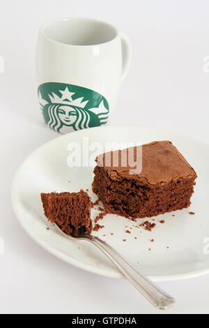 Stück Brownie und Starbucks Tasse Stockfoto