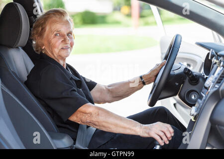 Ältere Frau hinter dem Lenkrad eines Autos Stockfoto