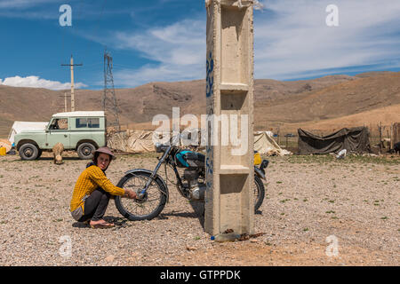Eine nomadische Qashqai Familie lebt in einem Zelt in der Provinz Fars, Iran. Tochter Donya arbeiten an ihrem Motorrad in der Nähe der Familienzelte. Stockfoto