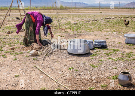 Eine nomadische Qashqai Familie lebt in einem Zelt in der Provinz Fars, Iran.  Mutter vorbereiten, draußen zu kochen. Stockfoto