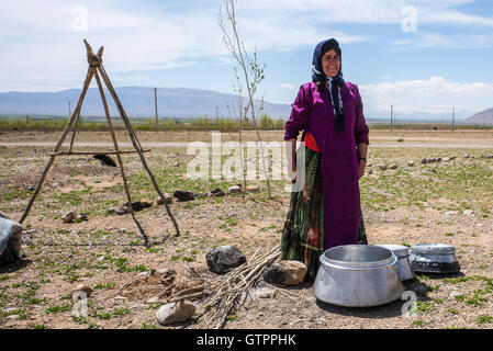 Eine nomadische Qashqai Familie lebt in einem Zelt in der Provinz Fars, Iran.  Mutter vorbereiten, draußen zu kochen. Stockfoto