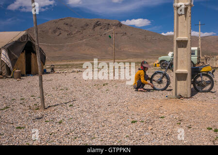Eine nomadische Qashqai Familie lebt in einem Zelt in der Provinz Fars, Iran.  Tochter Donya arbeiten an ihrem Motorrad. Stockfoto