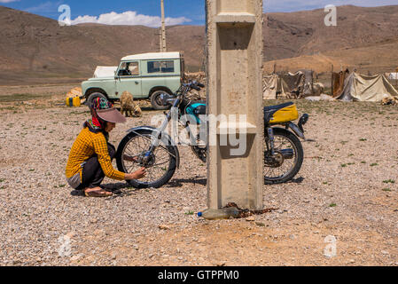 Eine nomadische Qashqai Familie lebt in einem Zelt in der Provinz Fars, Iran.  Tochter Donya arbeiten an ihrem Motorrad. Stockfoto