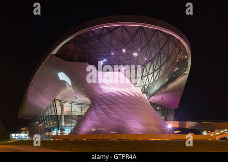 Lila und rosa beleuchteten Fassade der BMW Welt in München in der Nacht, Bayern, Deutschland Stockfoto