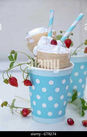 Eis mit Wald wilde Erdbeeren in einer Tasse blau mit weißen Tupfen Stockfoto