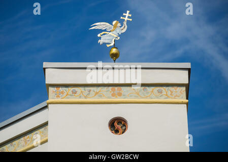 Vergoldete Metall Bild von einem Engel mit Kreuz gegen blauen Himmel auf mittelalterlichen Gebäude in der alten Stadt Wasserburg, Bayern, Deutschland Stockfoto