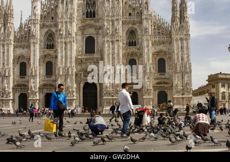 Mailand, Italien - 14. April 2015: Ausländische Touristen mit Tauben in Platz Piazza del Duomo in Mailand Stockfoto