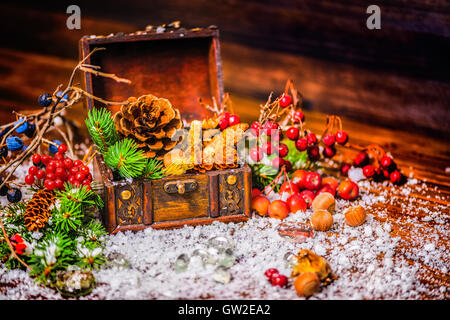 Thanksgiving Urlaub Hintergrund mit geöffneten Brust Schatz, Apfel, Nüssen, Zapfen, Beeren, Tanne und Schnee, ländlichen Stil, in der Nähe u Stockfoto