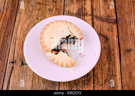 Mince Pies mit Berry Stau in auf einem weißen Teller auf dem Holztisch Stockfoto