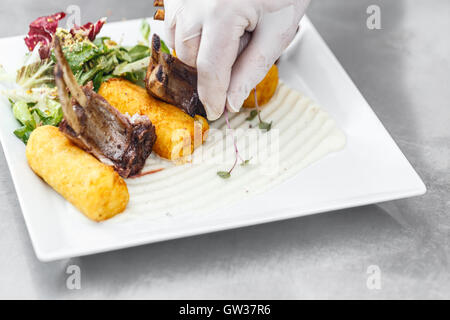 Gebratene Lammkoteletts garniert mit gestampften Kartoffeln gefüllte Kroketten Stockfoto