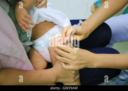 Kinder erhalten Impfstoff auf Seite des Oberschenkels. Kinder-Impfstoff. Stockfoto